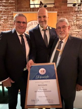 Bernd Kütscher (Mitte) mit der Urkunde zum Ehrensenator des Deutschen Brotsenats, links Verbandspräsident Norbert Lötz, rechts Achim Lohner.