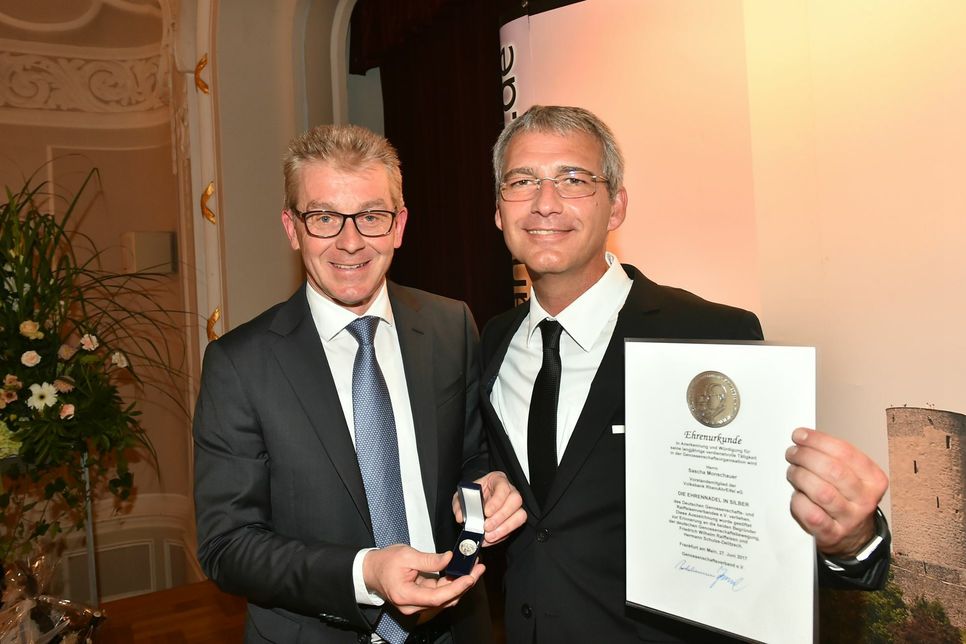 Michael Speth, Mitglied des Vorstands der DZ Bank AG (links), überreichte Sascha Monschauer die silberne Ehrennadel des Deutschen Genossenschafts- und Raiffeisenverbandes für sein Engagement im Genossenschaftssektor.