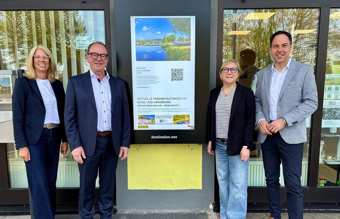 Stefanie Koch (Geschäftsführerin der Saar-Obermosel Touristik), Jürgen Dixius (Bürgermeister der VG Saarburg-Kell), Sonja Rommelfanger (Projektleiterin Saar-Obermosel Touristik) und Guido Wacht (Bürgermeister der VG Konz) bei der neuen digitalen Infostele.