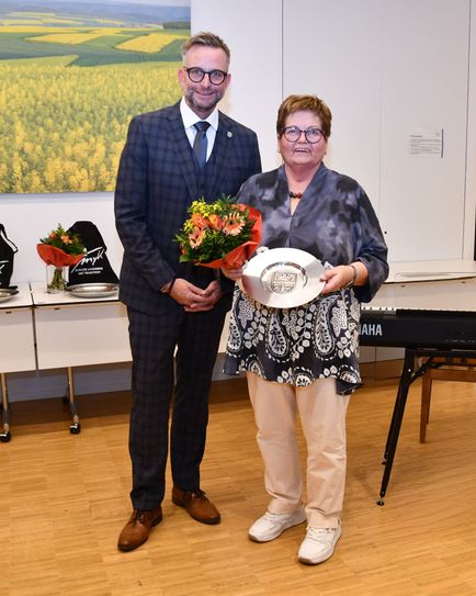 Landrat Marko Boos überreicht Hiltrud Surges aus Mendig den Wappenteller.