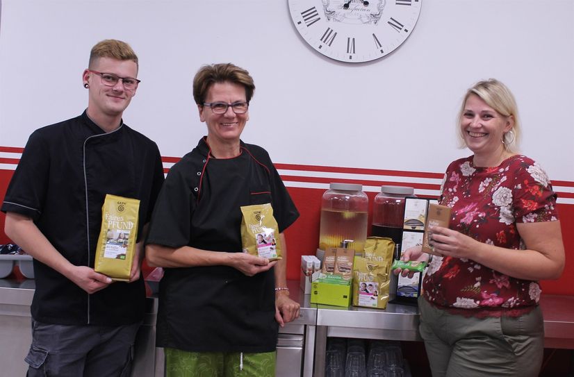Stephanie Wollgarten (Hausleitung), Ursula Justen (Küchenleitung) und Nico Baales (Mitarbeiter Küche) präsentieren das Fairtrade-Angebot der Jugendstätte Rursee.