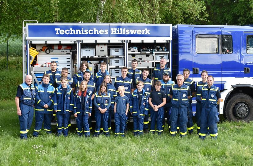 Helferinnen und Helfer des THW Ortsverbandes Simmern vor dem Gerätewagen, der in jedem Ortsverband deutschlandweit gleich ausgestattet ist.