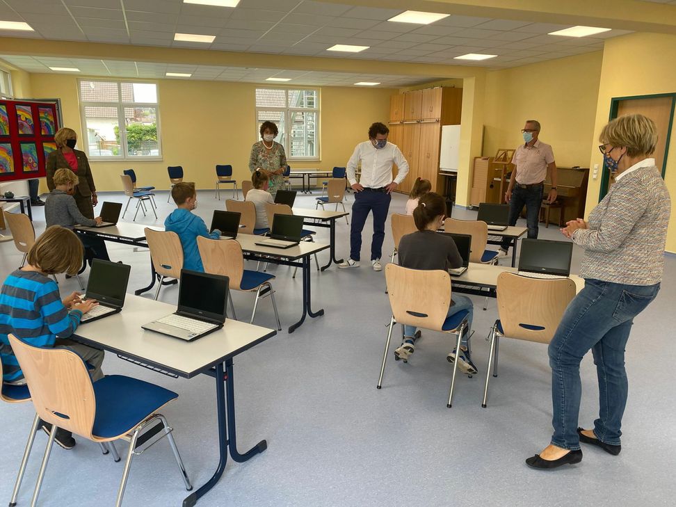 Einige Schülerinnen und Schüler der vierten Klasse der Grundschule Arloff an ihren neuen Laptops neben der Schulleiterin, Renate Lüdenbach, der Bürgermeisterin Sabine Preiser-Marian, der Pressesprecherin der Provinzal-Versicherung, Martina Hankammer, dem Vertreter der Elternpflegschaft, Ronald Larmann, und dem Leiter des Stadtschulamtes, Hans-Josef Dederichs. Fotos: M. Hochgürtel/Stadt Bad Münstereifel