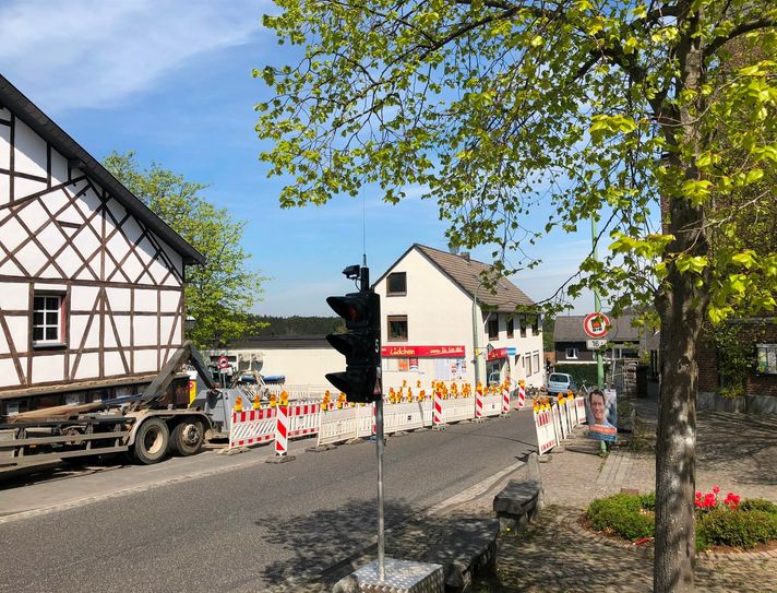 Der Dorfkern von Rott wird mit neuem Pflaster aufgehübscht: Dazu wird bis Ende Mai am Saal Hütten gebaut - mit notwendiger Ampelschaltung auf der Quirinusstraße. Kunden des Rotter Lädchens müssen im näheren Umkreis parken oder zu Fuß / mit dem Rad einkaufen.