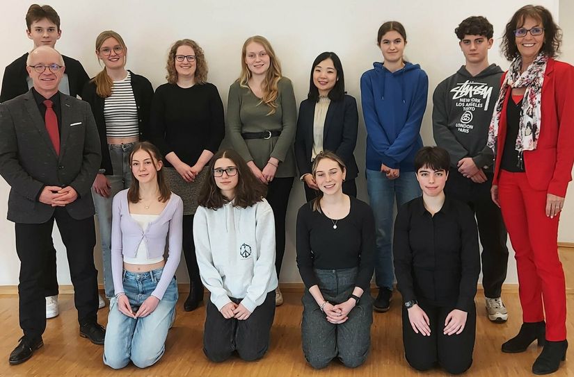 Zehn junge Bopparderinnen und Bopparder besuchen zu Pfingsten gemeinsam mit Boppards Bürgermeister und Delegationsleiter Jörg Haseneier (links) und Mitarbeiterin Martina Weirich (rechts) das Land der aufgehenden Sonne. Im japanischen Generalkonsulat in Frankfurt vermittelte Vizekonsulin Kotoe Otsuka (hinten, 4. von rechts) wichtige Grundlagen aus dem Leben und Alltag in Japan, wie den Fersensitz "Seiza" (vordere Reihe). Dies ist eine traditionelle japanische Sitzhaltung und in Japan eine sehr häufig verwendete Sitzweise.