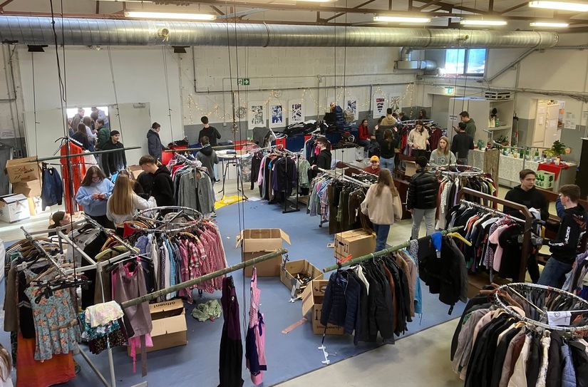 Jugendliche organisieren für andere einen Kleidermarkt.