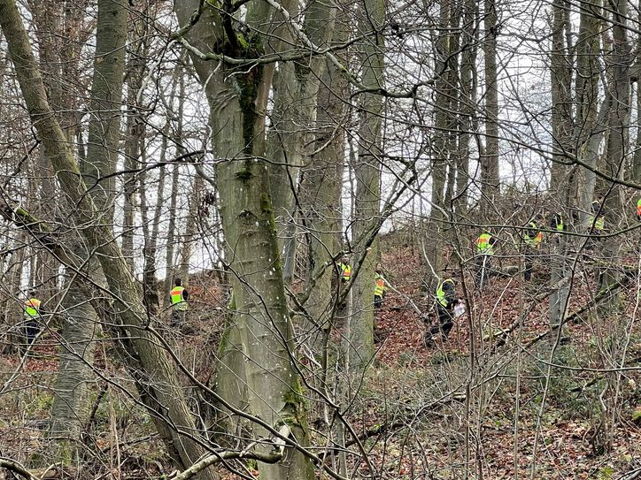 Einsatzkräfte prüfen das Gelände auf weitere Hinweise.
