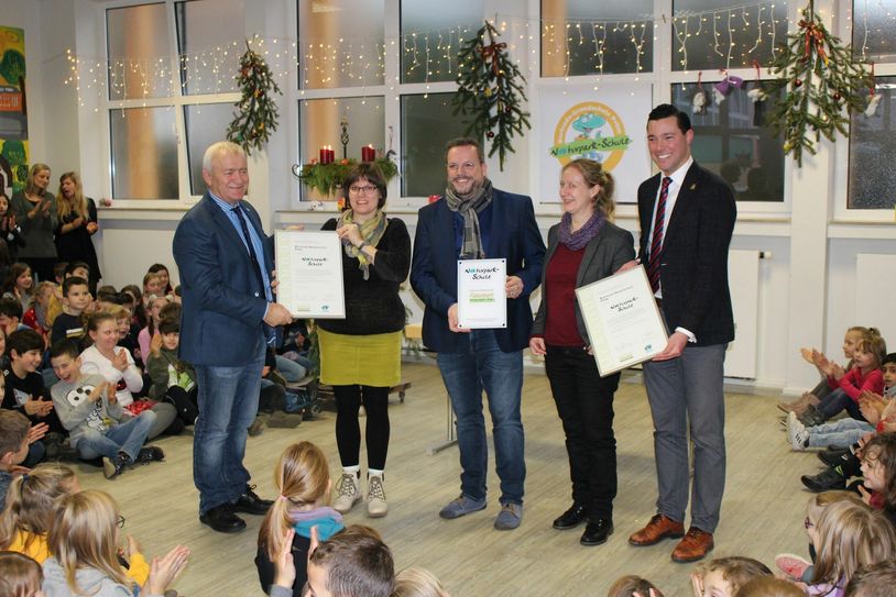 Gemeinsam mit Verbandsbürgermeister Aloysius Söhngen, Konrektorin Corinna Herf, Schulleiter Arnold Gierten, Naturpark-Geschäftsführerin Anne Derks und Stadtbürgermeister Johannes Reuschen (v.l.) feierten die Schülerinnen und Schüler der Bertrada-Grundschule Prüm die Auszeichnung zur „Naturpark-Schule“. Foto: A. Herf