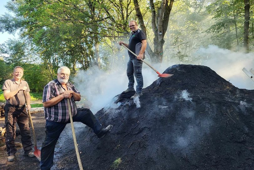 Alles unter Kontrolle haben Köhlermeister Gerd Linden (m.) und seine Gesellen Markus "Bienchen" Schmitz (l.) und Sohn und "Köhlerbube" Markus Linden.