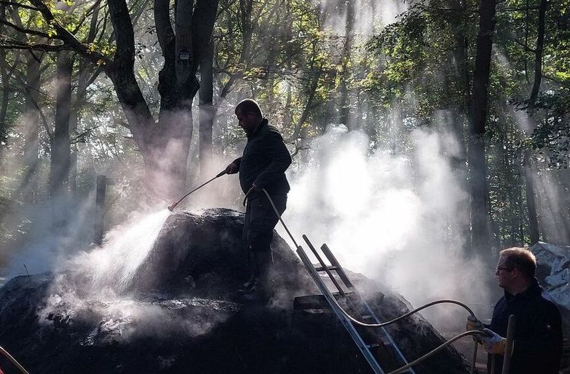 Köhlerromantik im Abendgegenlicht: Wenn Holzkohleherstellung so einfach ginge wie im Lexikon, wäre alle Kunstfertigkeit und Sinnenfreude eines uralten Handwerks dahin, mit dem aus schwerem Holz leichte Kohle mit extremem Brennwert gemacht wird.