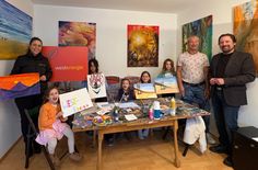 Peter Unkel, Bürgermeister der Verbandsgemeinde Hunsrück-Mittelrhein (rechts), Melanie Dindorf, Westenergie-Kommunalmanagerin (links), sowie Dr. Armin Thommes, freier Künstler und Privatdozent der Malerei (2. v. r.), mit den jungen Künstlerinnen und Künstler im Atelier in Urbar.