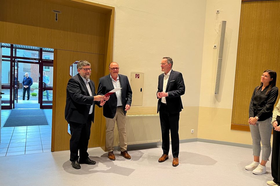 Innenminister Michael Ebling (rechts) übergibt Stefan Thomas, Bürgermeister der Ortsgemeinde Faid (Mitte), sowie Wolfgang Lambertz, Bürgermeister der VG Cochem (links) der Förderbescheid.