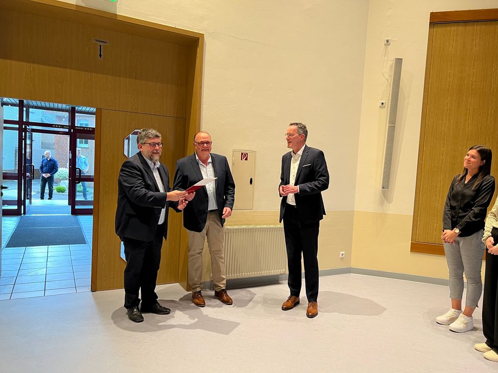 Innenminister Michael Ebling (rechts) übergibt Stefan Thomas, Bürgermeister der Ortsgemeinde Faid (Mitte), sowie Wolfgang Lambertz, Bürgermeister der VG Cochem (links) der Förderbescheid.