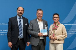 Auszeichnung der Stadt Euskirchen als »Aufsteiger des Jahres« 2026, v.l.n.r.: Marc Gebauer (Sprecher der Initiative Pro Recyclingpapier), Sacha Reichelt (Bürgermeister der Stadt Euskirchen), Parlamentarische Staatssekretärin Rita Schwarzelühr-Sutter.