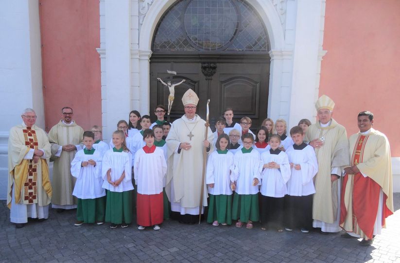 Bischof Ackermann mit den Prümer Messdienern vor der frisch eingeweihten Basilika in Prüm. Foto: Kerstin Bormann