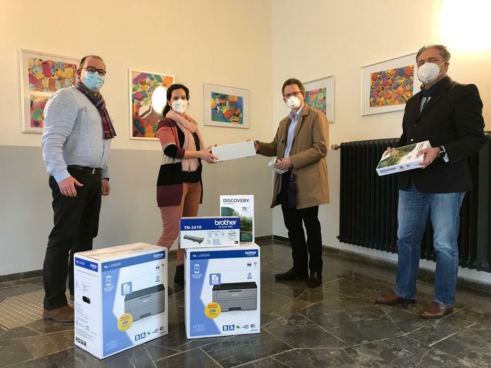 Schulleiter Dr. Bernd Gotzen sowie Isabel Pilz, Dr. Withold Wollgarten und Peter Plewa vom Verein »Hilfe schenken« bei der Übergabe der Drucker. Foto: Stein