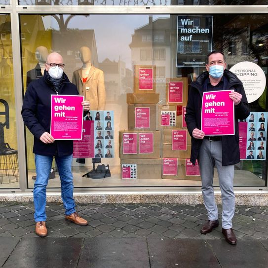 Oberbürgermeister Dirk Meid und der Geschäftsführer des Modehaus Küster Markus Schmitt machen auf die Aktion freundschaftsdienst.eu aufmerksam. Foto: Modehaus Küster