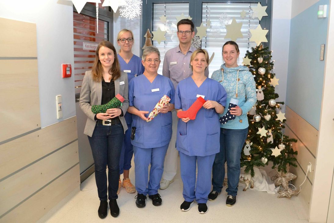 Die von Viviane Leyhausen (r.) gespendeten, prall gefüllten Weihnachtsstiefel an die Familien der Frühgeborenen zu verschenken, darüber freut sich das Team der Kinderintensiv- und Frühgeborenen-Station im Klinikum Mutterhaus an Heilig Abend besonders: (v.l.n.r.) Verena Backendorf (Pflegedienstleiterin Kinder- und Jugendzentrum), Kerstin Wallerius (stellvertr. Stationsleiterin, Früh- und Neugeborenenstation), Petra Schumann (Stationsleiterin Kinderintensivstation), PD Dr. Wolfgang Thomas und Bianca Gorges (pflegerische Bereichsleiterin Neonatologie). Foto: Kristina Kattler