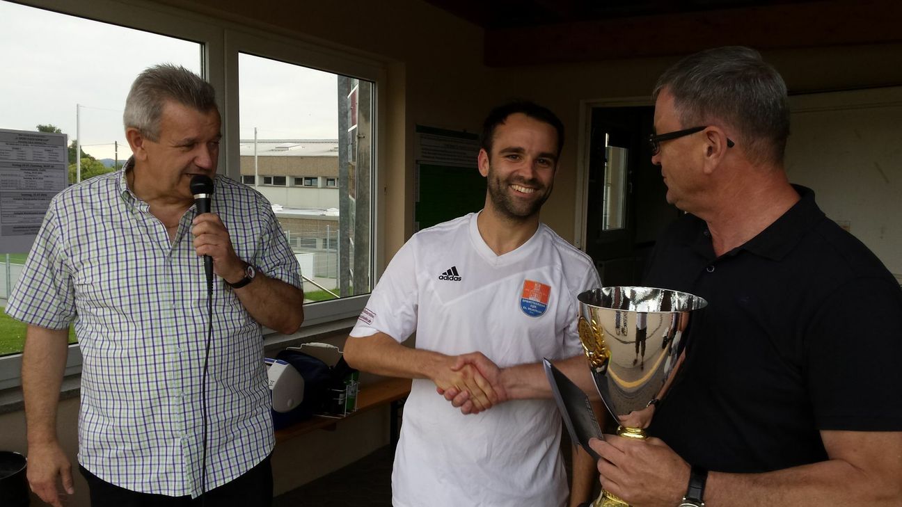 Im Bild: DJK-Vorsitzender Helmut Hein (links) und "Vize" Uwe Pasucha (rechts) bei der Siegerehrung mit DJK-Kapitän Patrick Dres. Foto: Arens