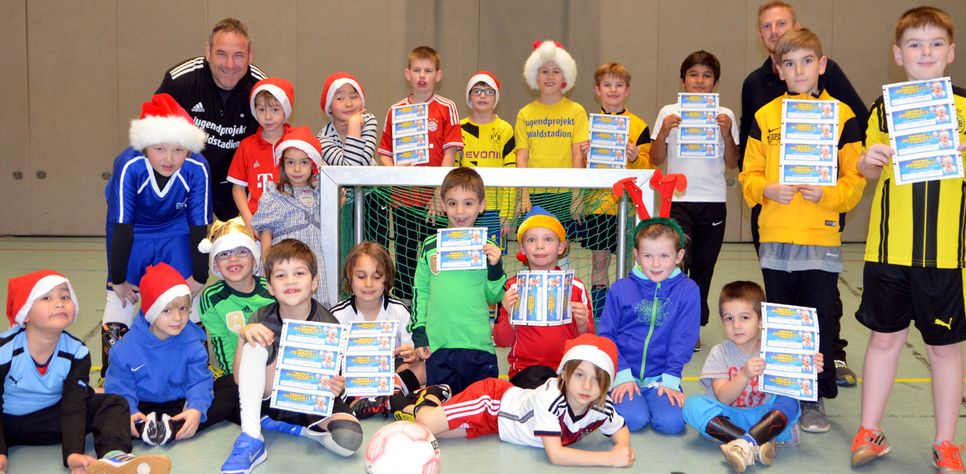 Freuen sich über ihre Einladung zum 12. Trierer Weihnachtscircus: die Kinder der WochenSpiegel-Patenschaft "Jugendprojekt Waldstadion" mit ihren Trainern Uli Morrissey (hinten, l.) und Markus Kuhn (hinten, r.) in der Sporthalle der Kurfürst-Balduin-Schule. Foto: Finkenberg