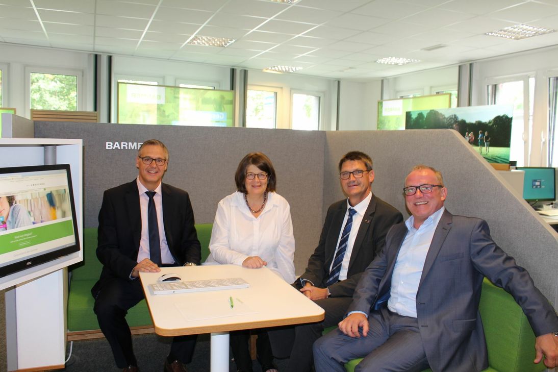 Sitzen Probe in einer Beratungsbox der neuen BARMER Geschäftsstelle in Trier (v.l.n.r.): Jörg Kalkstein (BARMER), Triers Bürgermeisterin Angelika Birk, der Landrat des Kreises Trier-Saarburg, Günther Schartz, und Guido Ernst (BARMER). (Foto: BARMER)