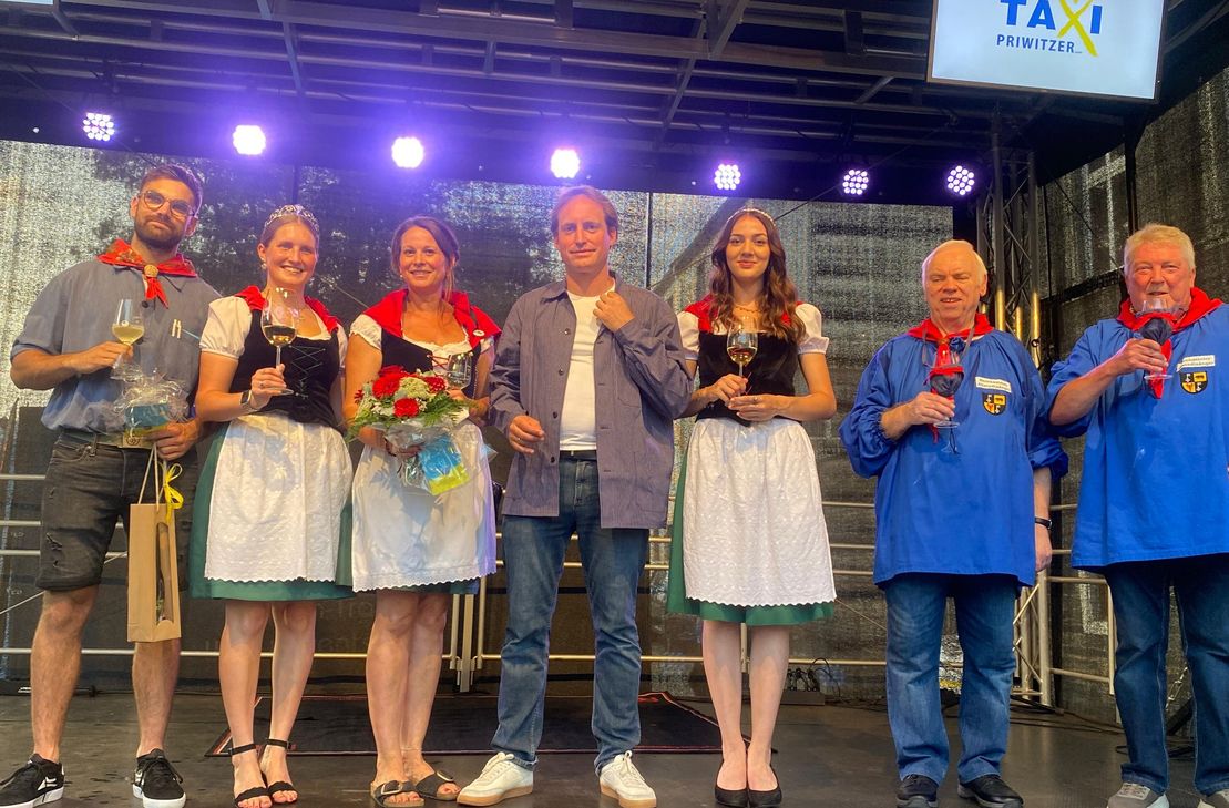 (v.li.): Marius Roß (Winzerkittel 2024), Mosella Franka I., Dominique Ruppenthal (Moselblümchen 2024), Stadtbürgermeister Roman Bastgen, Weinprinzessin Luna Nummer und die Altstadtsänger Peter Schmittgen und Wolfgang Gilles.