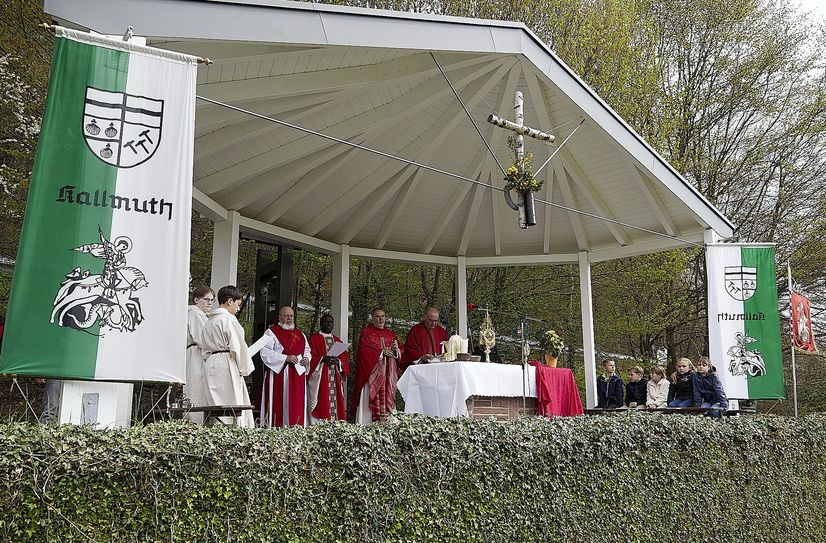 Auf einer überdachten Altarinsel am Georgspütz feiern die Geistlichen zusammen mit den Gläubigen unter freiem Himmel den Festgottesdienst.