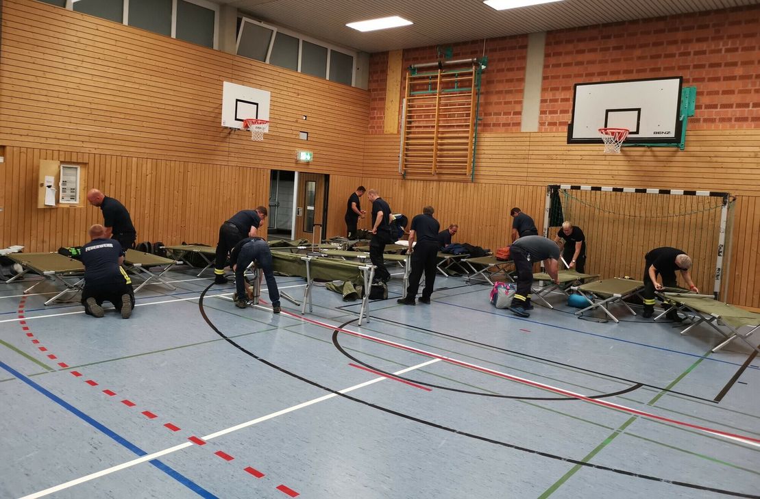 Aufbau der Feldbetten in Turnhalle.