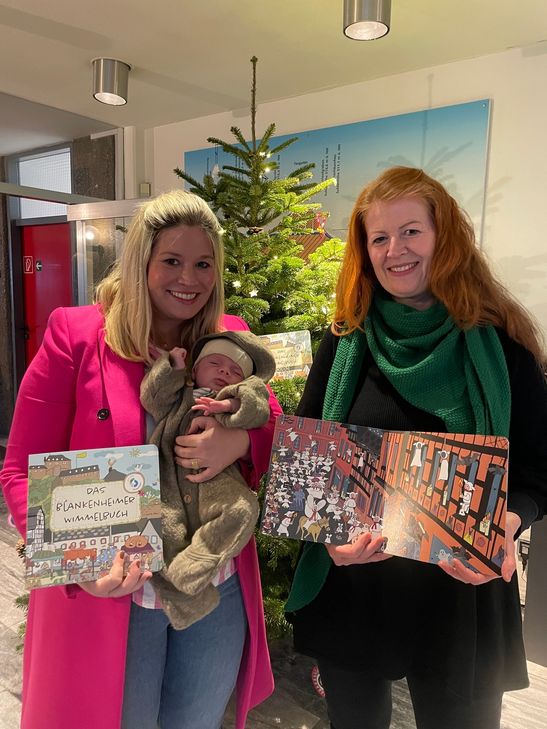 Die Bürgermeisterin Jennifer Meuren und ihr Sohn Levi (li.) freuen sich über das Buch, das Judith Maur designt hat.