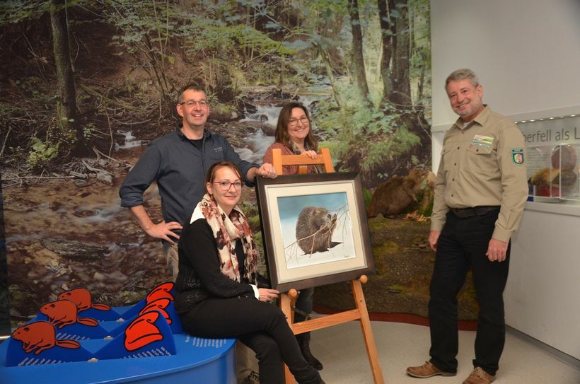 Maler Udo Bongard (l.) stellt in der Weihnachtszeit seine Tier-Gemälde im Nationalparktor in Rurberg aus. Nun hat er der touristischen Anlaufstelle ein Biber-Bild geschenkt - sehrt zur Freude von Cornelia Freuen und Astrid Joraschky (beide Rursee-Touristik) sowie Michael Lammertz (Nationalpark-Verwaltung).Foto: T. Förster