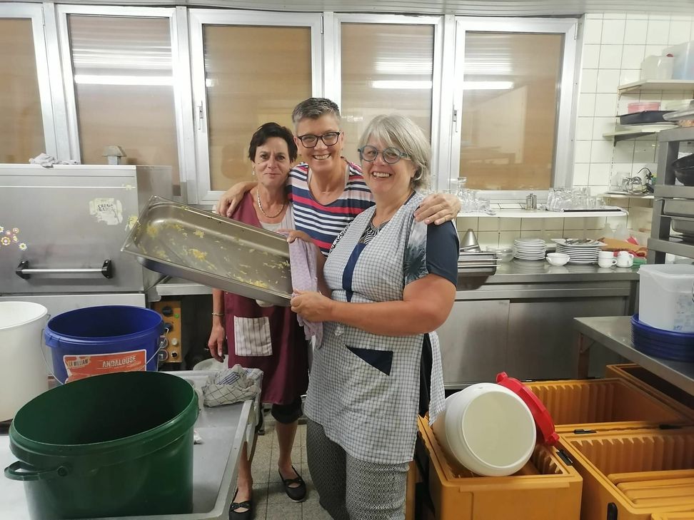 Freiwillige Helfer unterstützen in der Küche, in der Mitte sieht man Anja Schneider. Foto: Privat