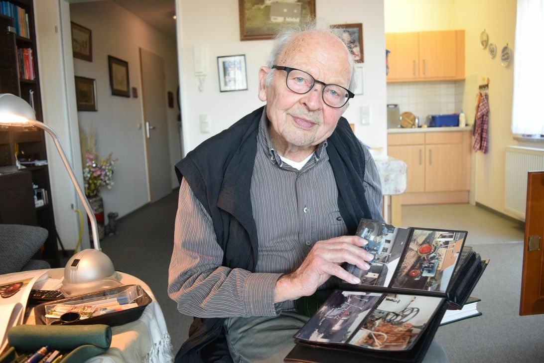 Johannes Leyendecker schwelgt beim Durchblättern seines Fotoalbums in Erinnerungen an seinen alten Traktor. Foto: Breuer