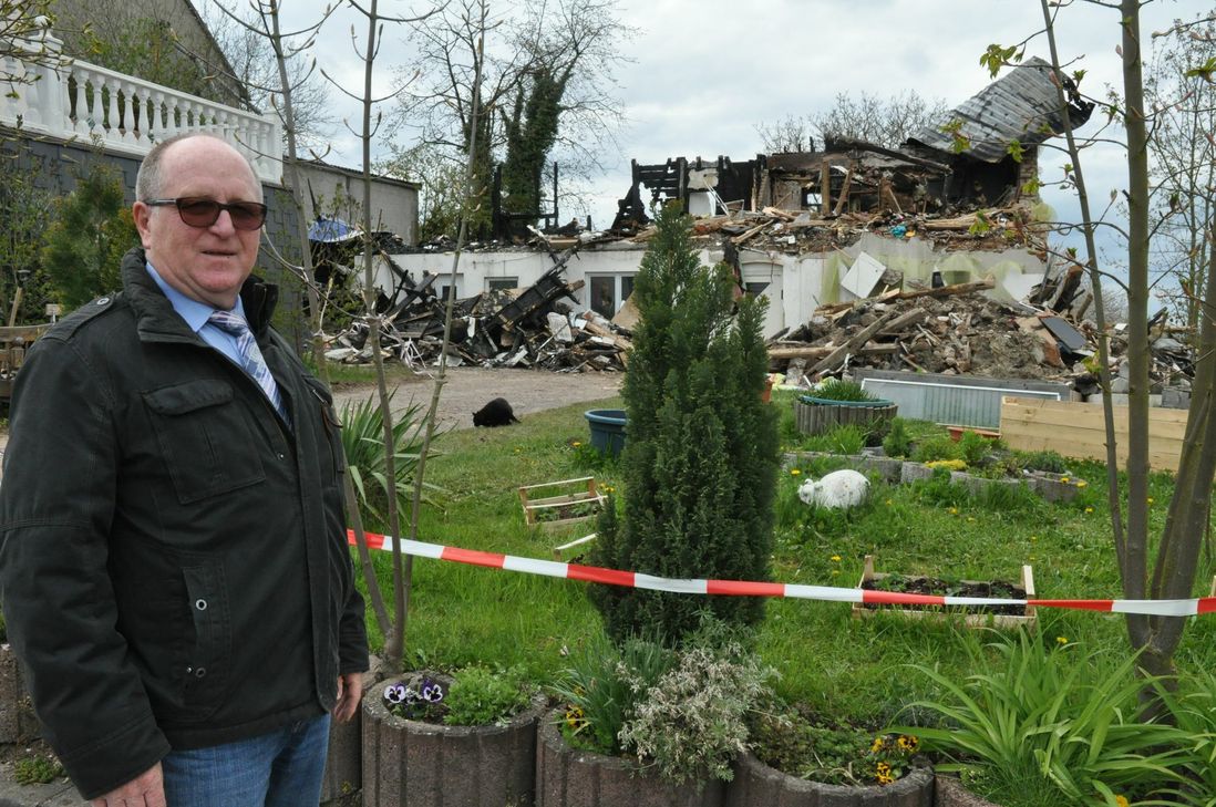 Der Brand und seine Folgen: Ortsbürgermeister Willi Lehnert an einem Berg von Schutt, den das Feuer vom Haus der Familie Gerlach übrig gelassen hat.