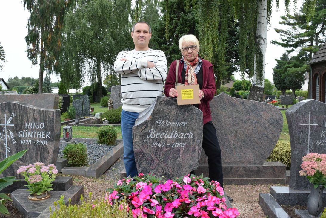 Der Grabstein ist erst 15 Jahre alt und muss nun trotzdem repariert werden. Darüber sind Michael, Thomas (fehlt auf dem Bild) und Sieglinde Breidbach wütend.  Foto: Breuer