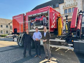 Thomas Jahnke von der VG-Verwaltung, der erste hauptamtliche Beigeordnete der VG Konz, Marcel Dawen, und Bürgermeister Guido Wacht mit dem neuen Abrollbehälter.