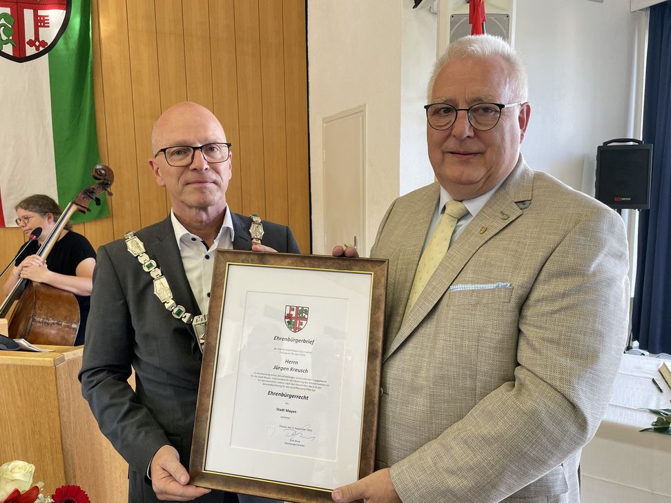Oberbürgermeister Dirk Meid übergibt den Ehrenbürgerbrief an Jürgen Kreusch.