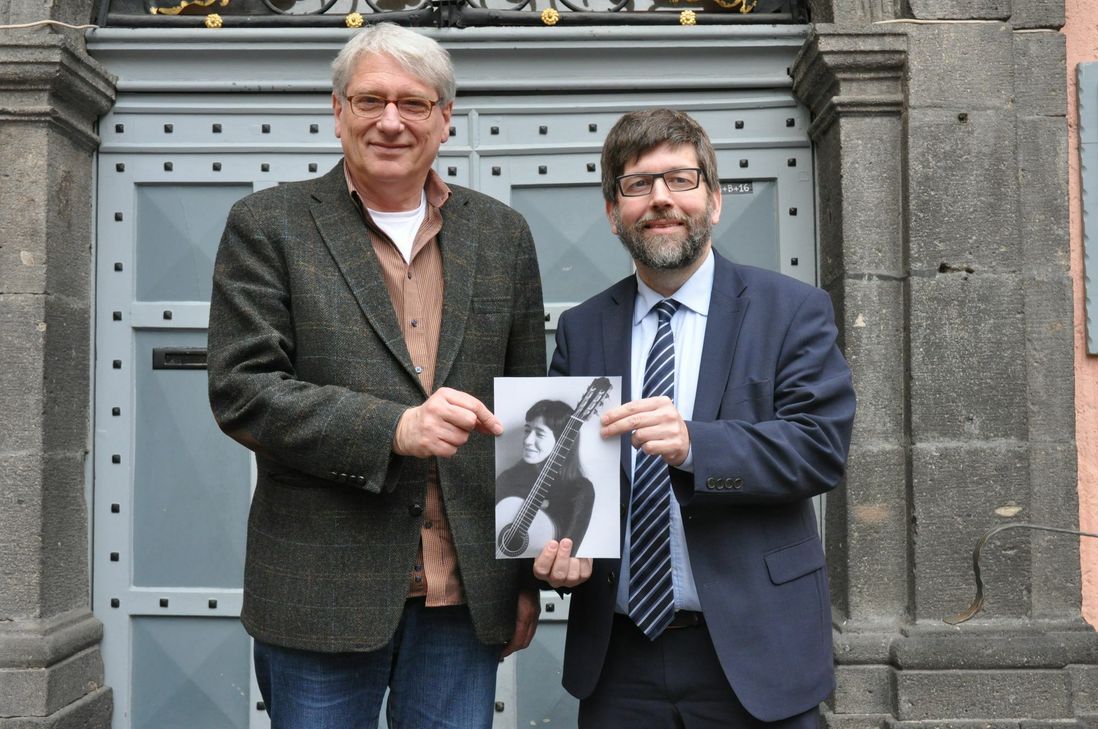 Vorfreude: Hans Thill (links), künstlerischer Leiter des Künstlerhauses Edenkoben, und Cochems Stadtbürgermeister Wolfgang Lambertz mit einem Bild der Gitarristin Cristina Azuma, die bei der "Brazilian Night" in der Moselstadt auftreten wird.