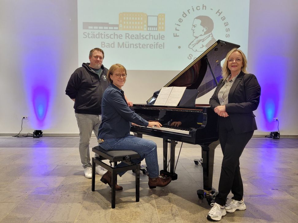 Den Klang des neuen Flügels testete Andrea Cosman (M.), Rektorin der Realschule, mit dem Beatles-Song »Yesterday«. Viktor Fröse (l.), Leiter der Friedrich-Haass-Schule, und Bürgermeisterin Sabine Preiser-Marian stimmten mit ein.