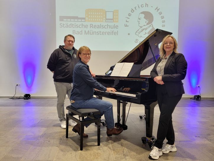 Den Klang des neuen Flügels testete Andrea Cosman (M.), Rektorin der Realschule, mit dem Beatles-Song »Yesterday«. Viktor Fröse (l.), Leiter der Friedrich-Haass-Schule, und Bürgermeisterin Sabine Preiser-Marian stimmten mit ein.