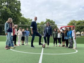 Bürgermeister Jan Lembach und Schulleiterin Mirjam Schmitz beim offiziellen Anstoß auf dem neuen Soccer-Court, der bei den Schülern der Grundschule Dahlem bestens ankommt - gerade in Zeiten der Fußball-WM.