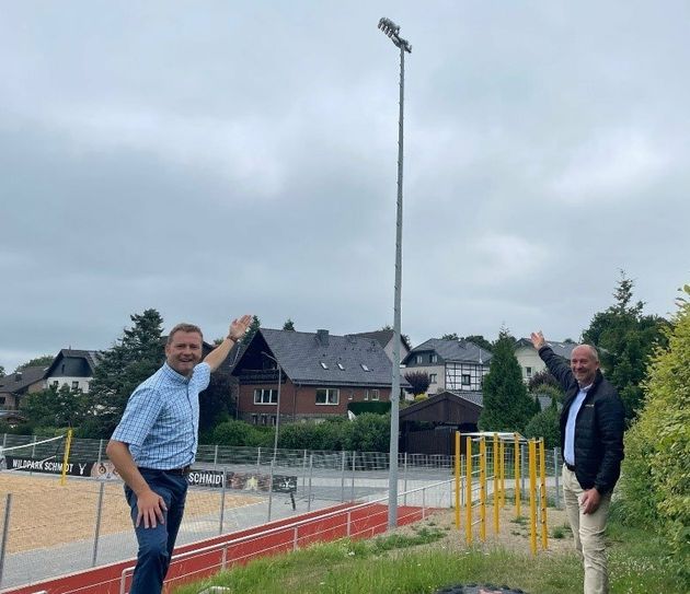 Bürgermeister Marco Schmunkamp und Achim Diewald von Westenergie freuen sich über neues Licht für die Schmidter Sportanlage.