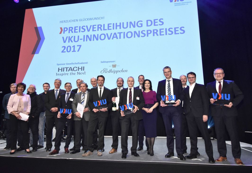 Moderatorin Ursula Heller (Bayerischer Rundfunk), VKU-Präsident Michael Ebling, VKU-Hauptgeschäftsführerin Katherina Reiche, Dr. Olaf Heil (Hitachi), SWT-Technikvorstand Arndt Müller (rechts im Bild), sowie weitere Gewinner des Innovationspreises 2017. Foto: SWT