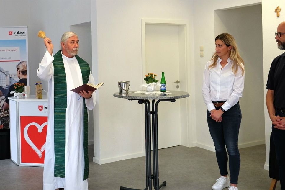 Pfarrer Peter Wycislok segnet das neue Fluthilfebüro der Malteser. Mit auf dem Foto sind Eva Eumes, Leiterin des Fluthilfebüros sowie Axel Rottländer, Leiter der Malteser Fluthilfe in NRW.