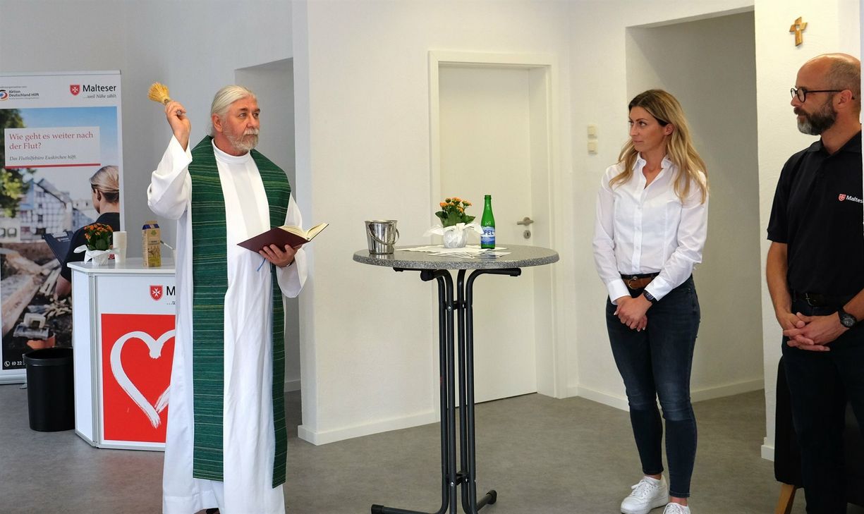 Pfarrer Peter Wycislok segnet das neue Fluthilfebüro der Malteser. Mit auf dem Foto sind Eva Eumes, Leiterin des Fluthilfebüros sowie Axel Rottländer, Leiter der Malteser Fluthilfe in NRW.