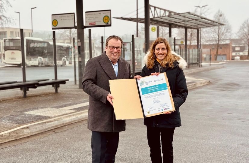 NRW-Verkehrsminister Oliver Krischer übergibt am Imgenbroicher Bushof die Urkunde an Bürgermeisterin Dr. Carmen Krämer, mit der die Stadt Monschau offiziell ins »Zukunftsnetzwerk Mobilität NRW« aufgenommen ist.