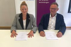 Anne Baedke, Abteilungsleiterin Westconnect, sowie Landrat Stefan Metzdorf beim Unterzeichnen des Kooperationsvertrages.
