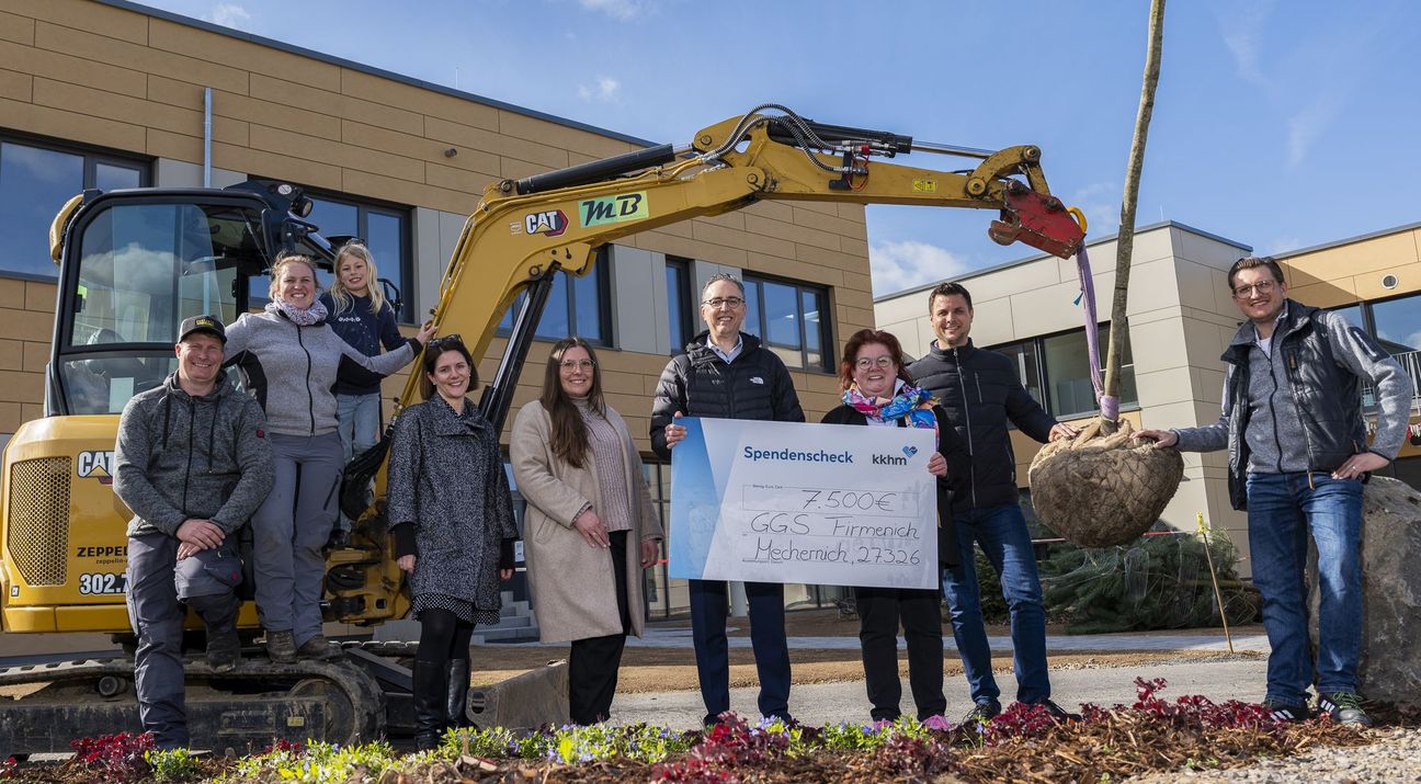 Symbolischer Scheck, echter Baum: Über die Spendenaktion des Kreiskrankenhauses freuten sich Marius (v.l.) und Stephanie Blum mit ihrer Tochter Marie, Jennifer Linke, Laura Lautz und Martin Milde vom Kreiskrankenhaus Mechernich, Schulleiterin Alexandra Offermann, Bürgermeister Michael Fingel und Fachbereichsleiter Christoph Breuer.