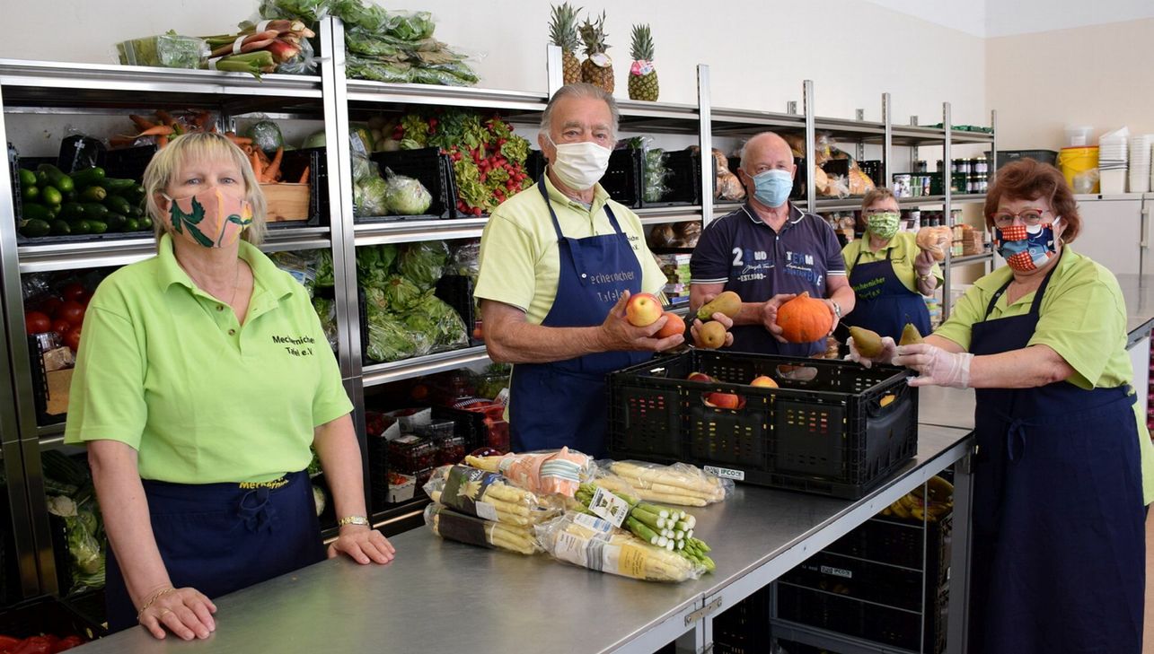 Mitarbeiter stehen bereit, um Bedürftige mit Nahrungsmittel zu versorgen. Gemäß einem ausgeklügelten Hygienekonzept wird jeder nur einzeln bedient. In den Warenraum dürfen aktuell nur Mitarbeiter hinein. Foto: Kirsten Röder/pp/Agentur ProfiPress