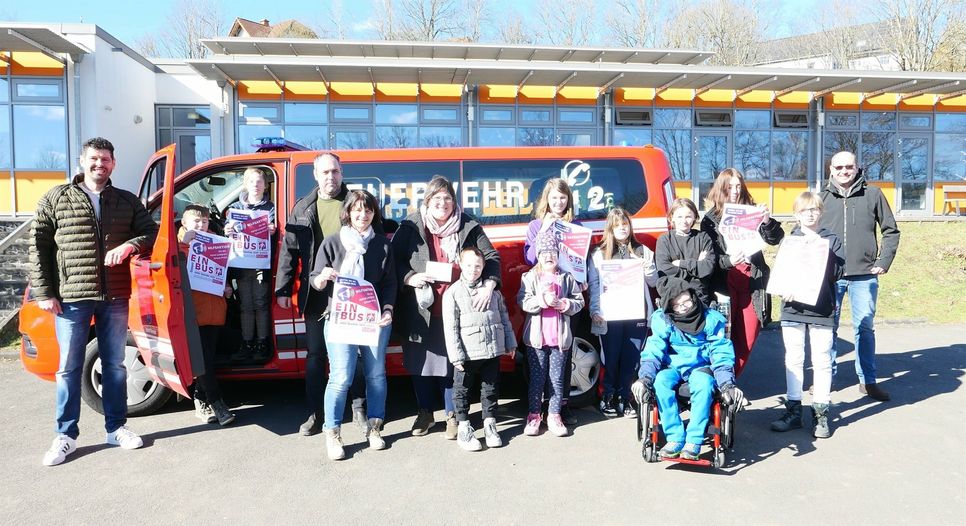 Eine Delegation der Feuerwehr Wiersdorf, mit Wehrführer Christian Theisen (links) spendeten 1500 Euro aus dem Erlös des Glühweinverkaufs für die Beschaffung des neuen Buses an die Astrid-Lindgren-Schule. Konrektorin Natalie Krütten (5.v.l.)  sowie Lehrerschaft und Kinder freuten sich über die Spende.