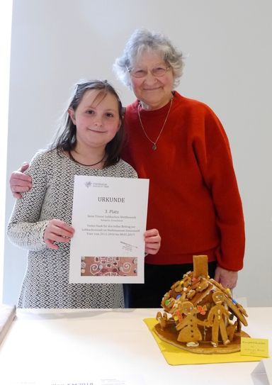 Walburga Bender aus Trier, die mit ihrem Beitrag "Knusperhäuschen" den 3. Platz in der Kategorie "Erwachsene" belegte und die Urkunde gemeinsam mit ihrer Enkelin in Empfang nahm. Foto: Stadtmuseum Simeonstift
